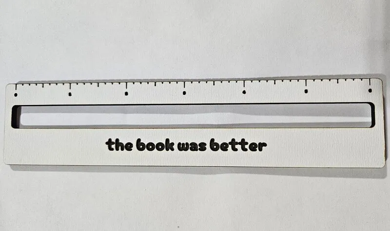 Reading guide with the text 'the book was better' laser cut in white plywood
